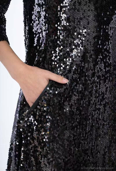 Lähikuva mustan Debbie-mekon paljettipinnasta ja sivutaskusta, mallin käsi taskussa.