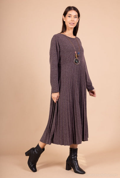 Pliseerattu helma laskeutuu keveästi Evelyn neulemekossa. Susanne