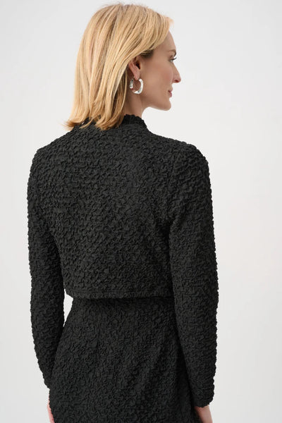 Tämä teksturoitu jacquard-bolero tuo tyylikästä ja ryhdikästä ilmettä mihin tahansa asuun. Mallissa on pitkät, suorat hihat, ja se on kevyt sekävuoriton, mikä luo selkeän ja modernin vaikutelman.